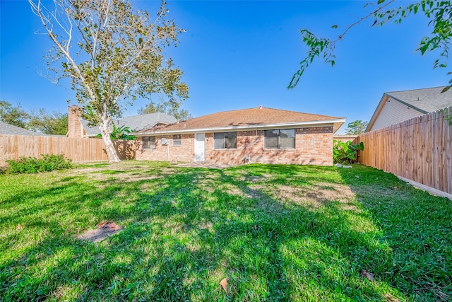 rear view of property with a yard