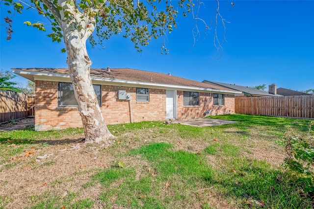 rear view of property featuring a yard and a patio