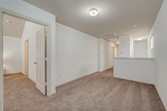 carpeted empty room with a textured ceiling