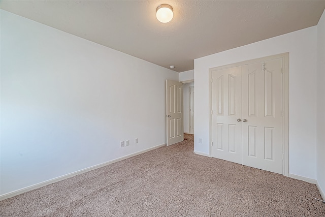 unfurnished bedroom with a closet and carpet floors