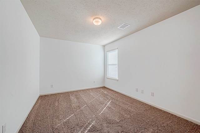 spare room with carpet and a textured ceiling