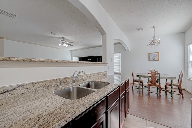 kitchen with a textured ceiling, light hardwood / wood-style flooring, a healthy amount of sunlight, and sink