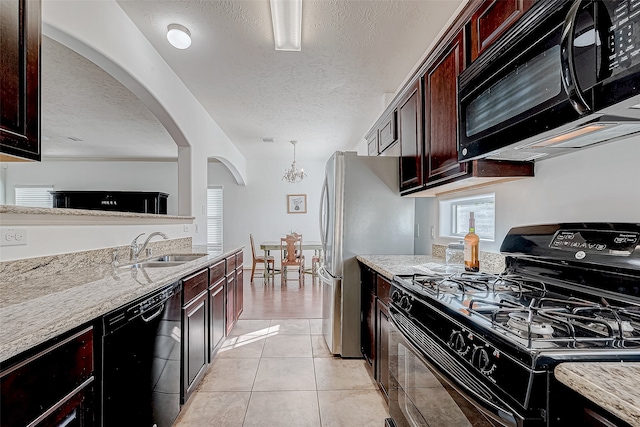 kitchen with an inviting chandelier, black appliances, sink, a textured ceiling, and light stone counters