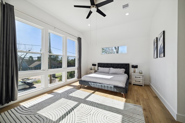 bedroom with dark hardwood / wood-style flooring, multiple windows, and ceiling fan