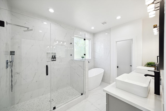 bathroom with vanity and shower with separate bathtub