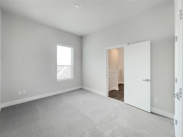 unfurnished bedroom with dark carpet, a walk in closet, and a closet