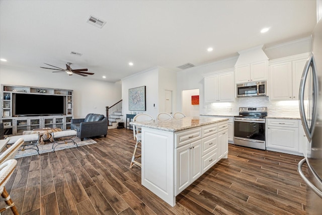 kitchen with white cabinets, appliances with stainless steel finishes, and a center island