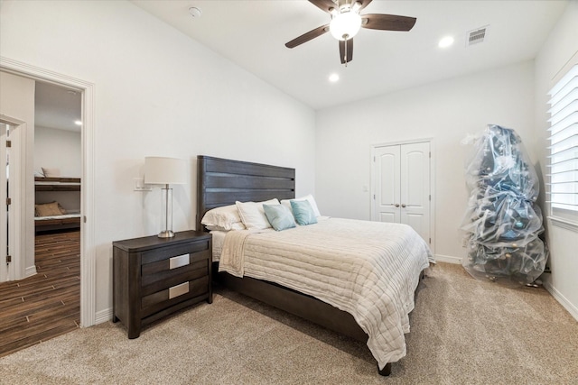 bedroom featuring hardwood / wood-style flooring, ceiling fan, a closet, and multiple windows