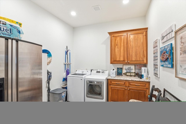 laundry area with washing machine and dryer and cabinets