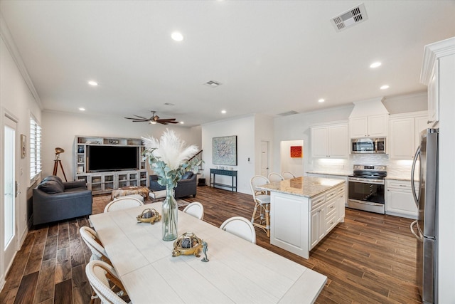 dining room featuring ornamental molding, ceiling fan, and dark wood-type flooring