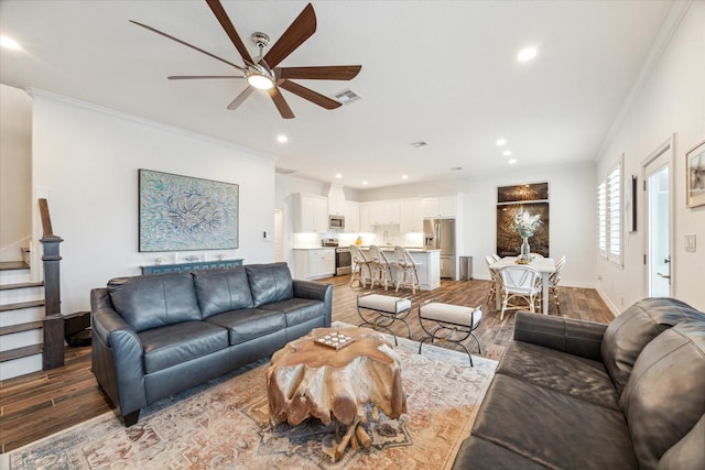 living room with hardwood / wood-style floors, ceiling fan, and crown molding