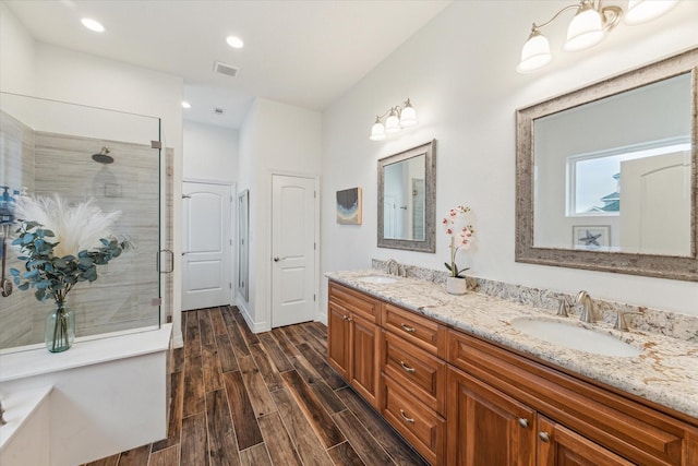 bathroom featuring vanity, hardwood / wood-style flooring, and a shower with shower door