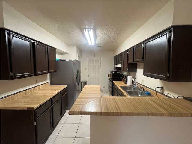 kitchen with dark brown cabinetry, sink, black electric range oven, kitchen peninsula, and a textured ceiling