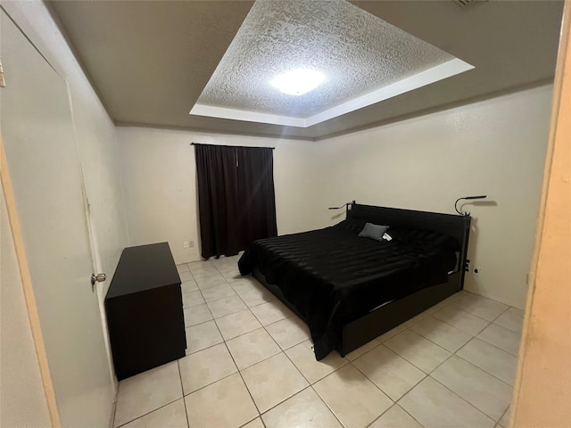 tiled bedroom with a raised ceiling and a textured ceiling