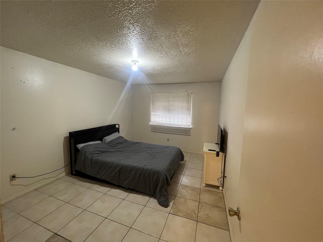 bedroom with light tile patterned floors and a textured ceiling