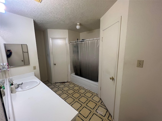 bathroom with vanity, shower / bath combination with curtain, and a textured ceiling