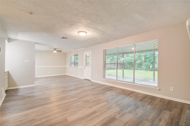 empty room featuring ceiling fan, wood-type flooring, and a textured ceiling