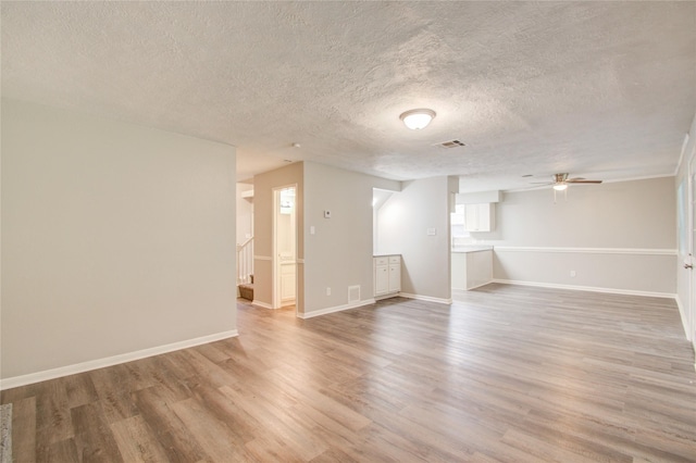 spare room with hardwood / wood-style flooring, ceiling fan, and a textured ceiling