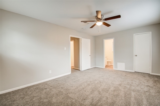 unfurnished bedroom with carpet floors, ceiling fan, and connected bathroom