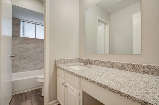 full bathroom featuring tiled shower / bath, toilet, vanity, and hardwood / wood-style flooring