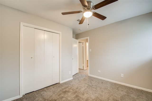 unfurnished bedroom with ceiling fan, light carpet, and a closet