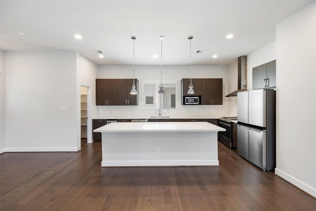 kitchen featuring dark brown cabinets, wall chimney exhaust hood, dark hardwood / wood-style floors, and appliances with stainless steel finishes