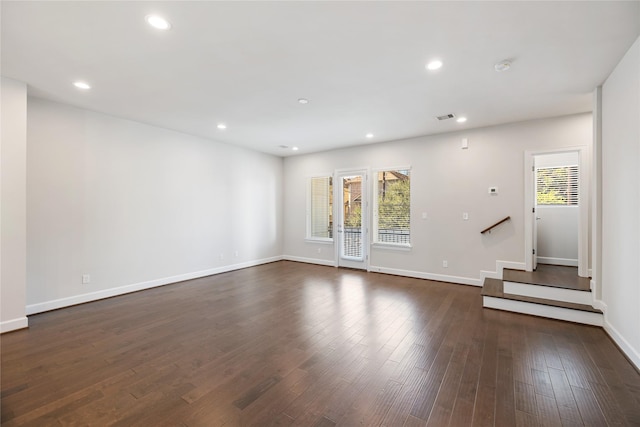 unfurnished living room featuring recessed lighting, dark wood finished floors, visible vents, and a healthy amount of sunlight