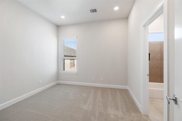 spare room with light colored carpet, visible vents, baseboards, and recessed lighting