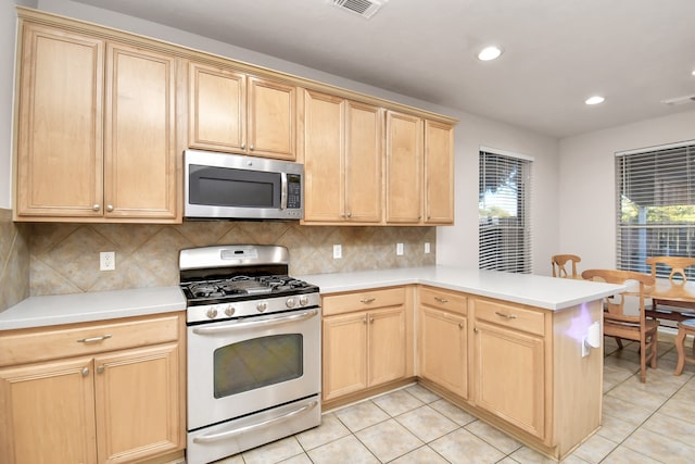 kitchen with tasteful backsplash, kitchen peninsula, light tile patterned floors, and stainless steel appliances