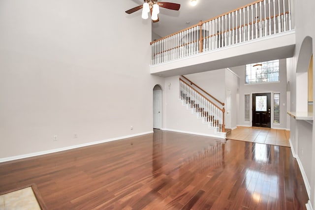 entryway featuring a high ceiling, hardwood / wood-style flooring, and ceiling fan