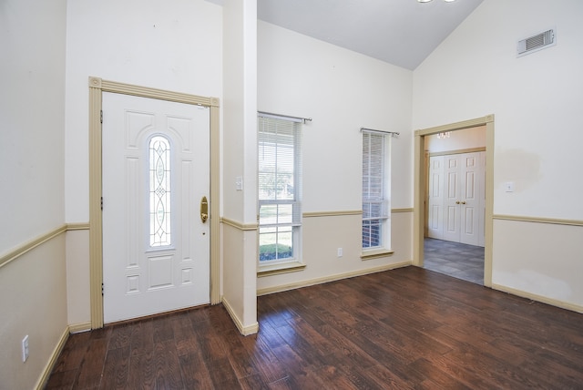 foyer with dark wood-type flooring and high vaulted ceiling