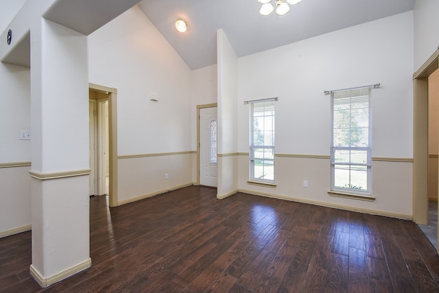 spare room with high vaulted ceiling and dark hardwood / wood-style floors