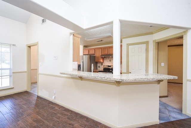 kitchen featuring kitchen peninsula, a kitchen bar, dark hardwood / wood-style flooring, and stainless steel appliances