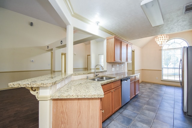 kitchen with backsplash, sink, a textured ceiling, appliances with stainless steel finishes, and kitchen peninsula