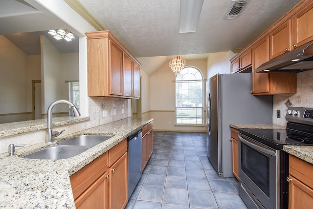 kitchen with light stone countertops, sink, stainless steel appliances, a notable chandelier, and decorative backsplash