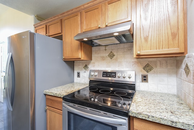 kitchen with decorative backsplash, a textured ceiling, stainless steel appliances, and light stone counters