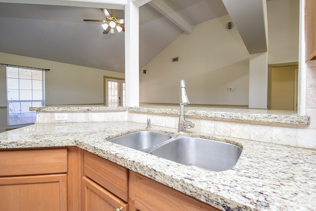 kitchen featuring a wealth of natural light, beam ceiling, ceiling fan, and sink