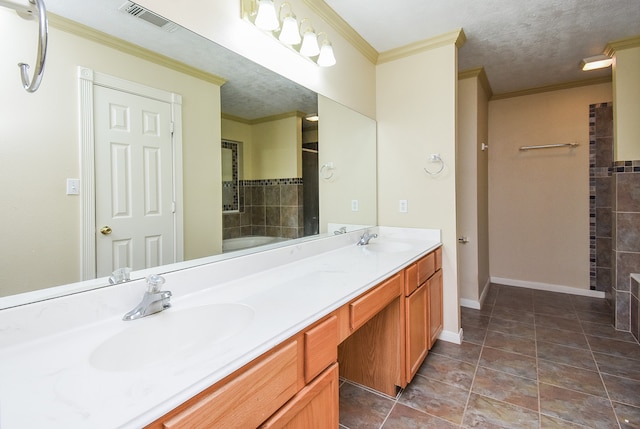 bathroom with tile patterned flooring, a textured ceiling, vanity, and ornamental molding