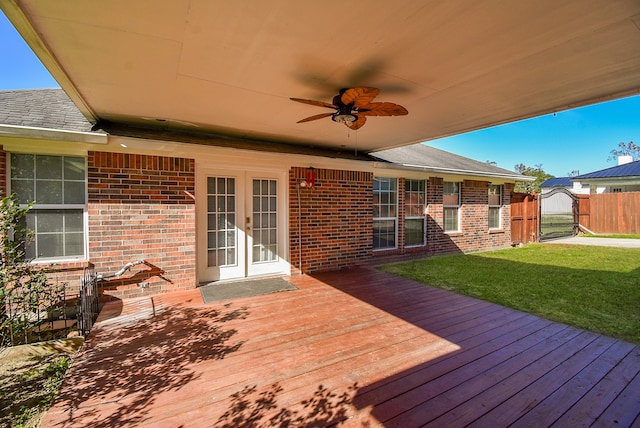 wooden deck featuring a lawn, ceiling fan, and french doors