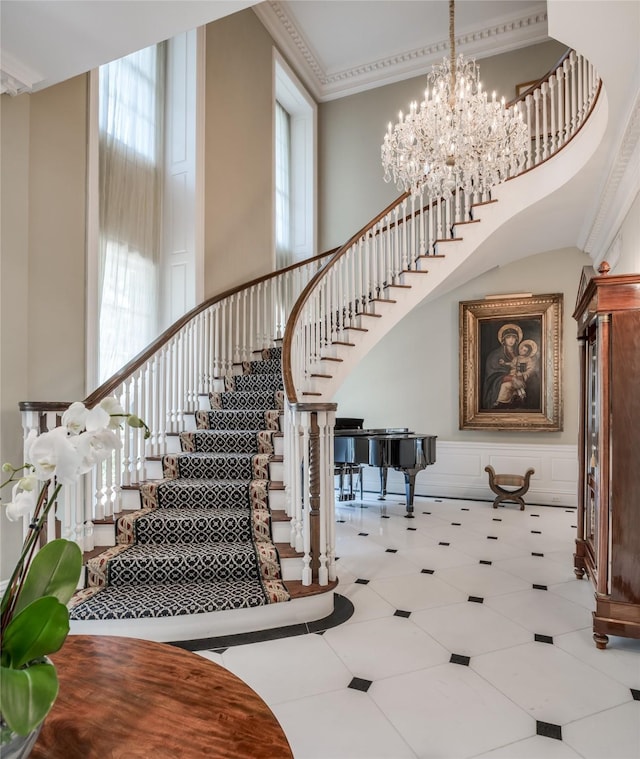 staircase featuring plenty of natural light, crown molding, a chandelier, and tile patterned flooring