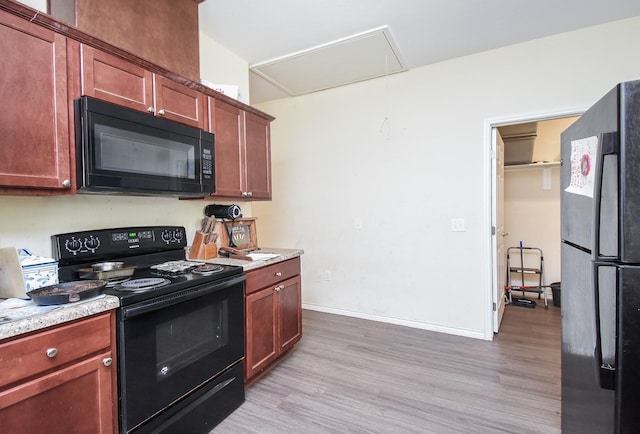 kitchen featuring black appliances and light hardwood / wood-style floors