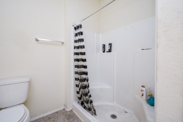 bathroom with tile patterned flooring, curtained shower, and toilet