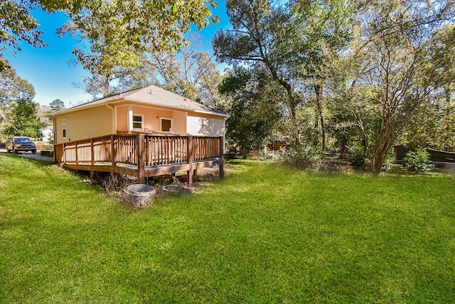 rear view of house with a lawn and a wooden deck