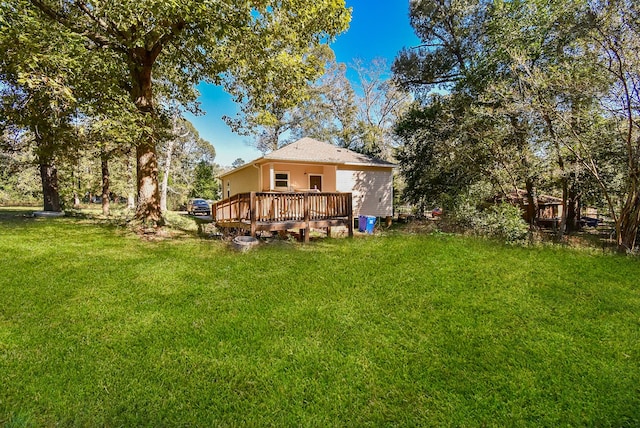 rear view of property with a deck and a yard