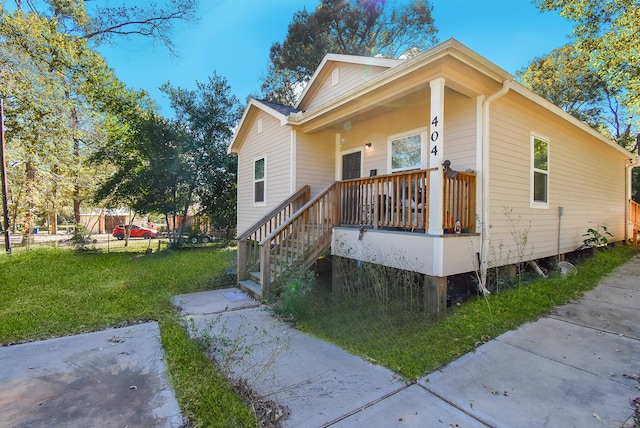 view of front of house featuring covered porch and a front yard