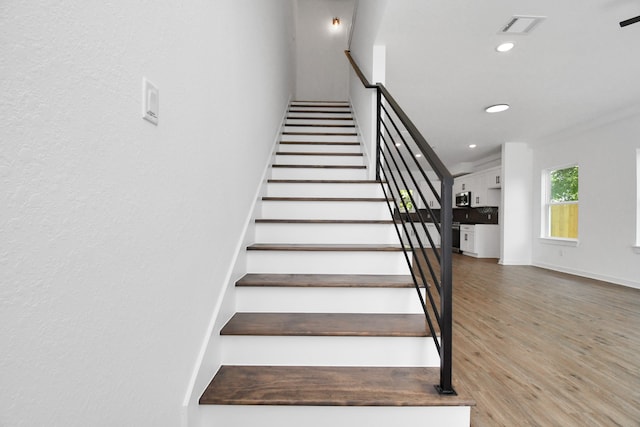 stairs featuring wood-type flooring