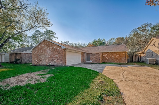 single story home featuring cooling unit, a front yard, and a garage