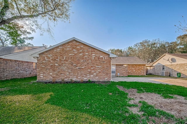 view of property exterior with a yard and central AC unit