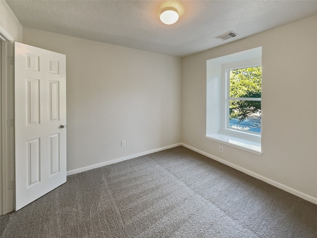 carpeted spare room with a textured ceiling