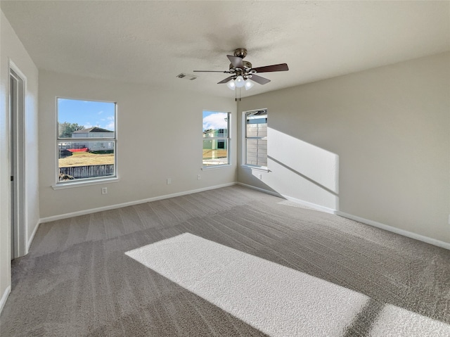 empty room with ceiling fan and carpet